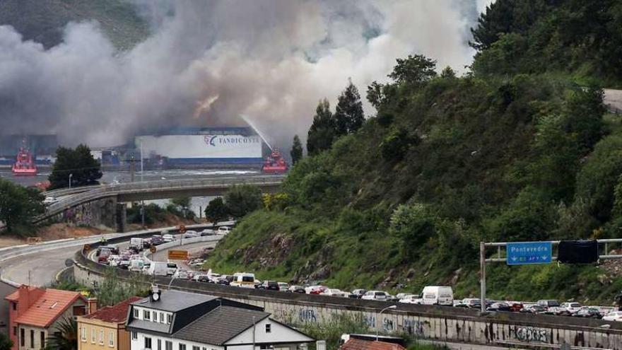 Coches atrapados en la autopista a su paso por Chapela, con el incendio al fondo. // José Lores