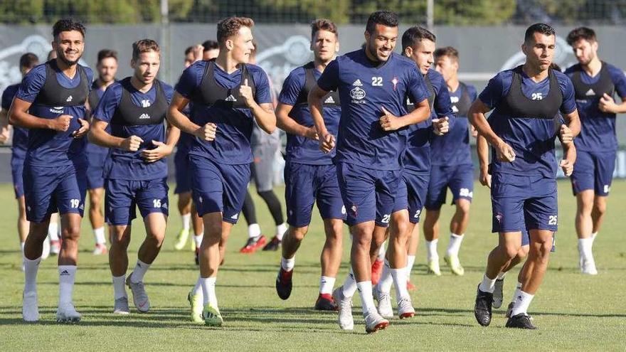 Los jugadores del Celta inician con una sonrisa la sesión de trabajo de ayer en A Madroa. // Ricardo Grobas