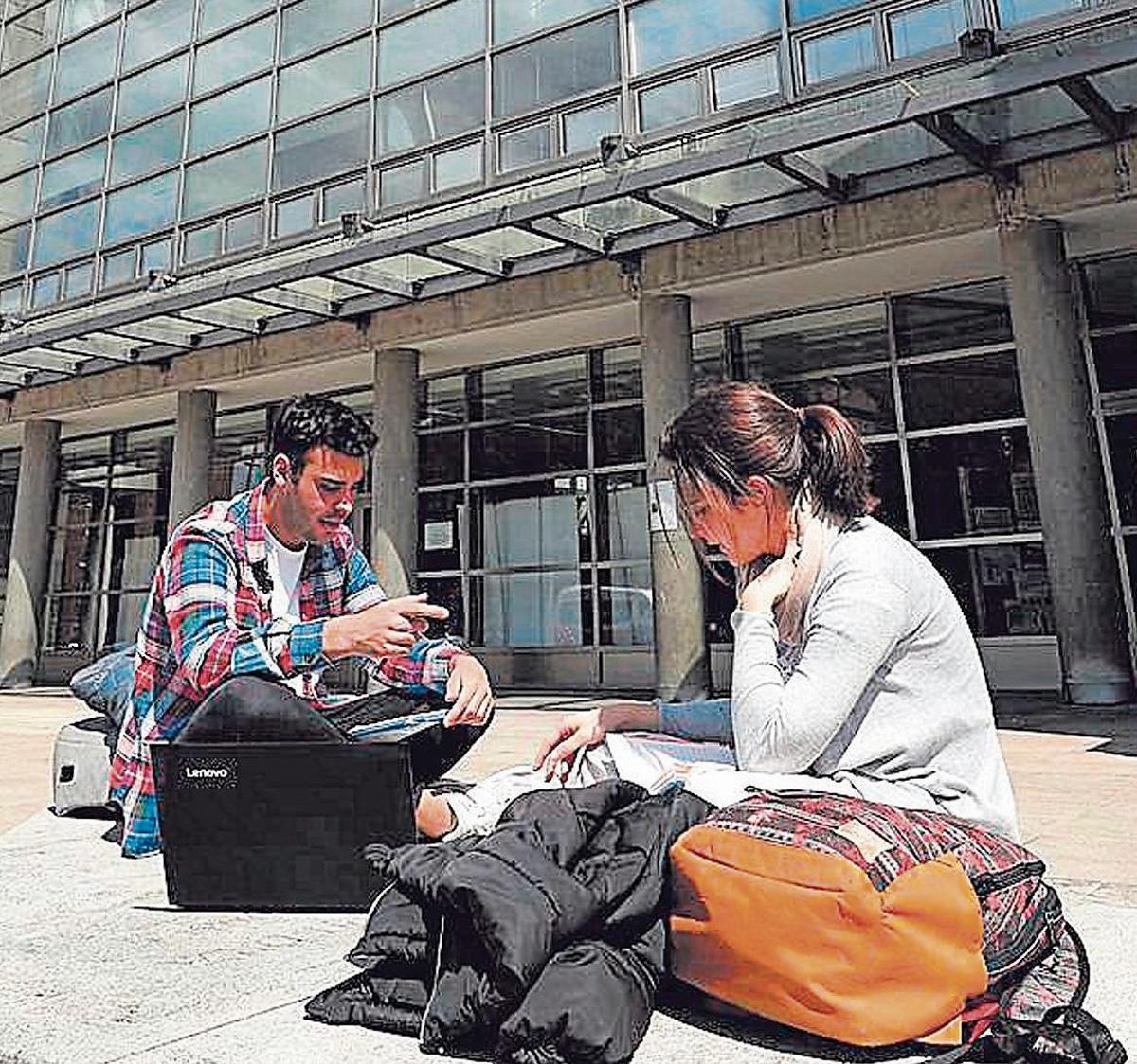 Dos estudiantes, ante la entrada del edificio principal del campus de Mieres