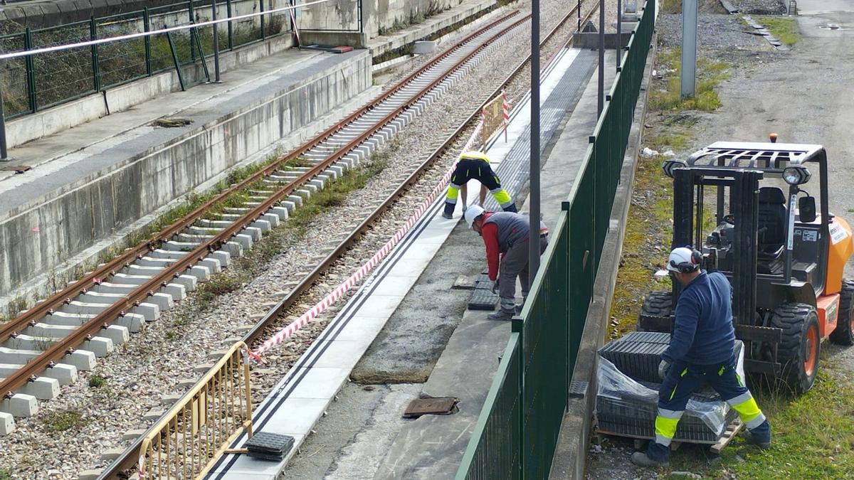 Trabajadores realizando tareas de pavimentación en la estación de Sama.