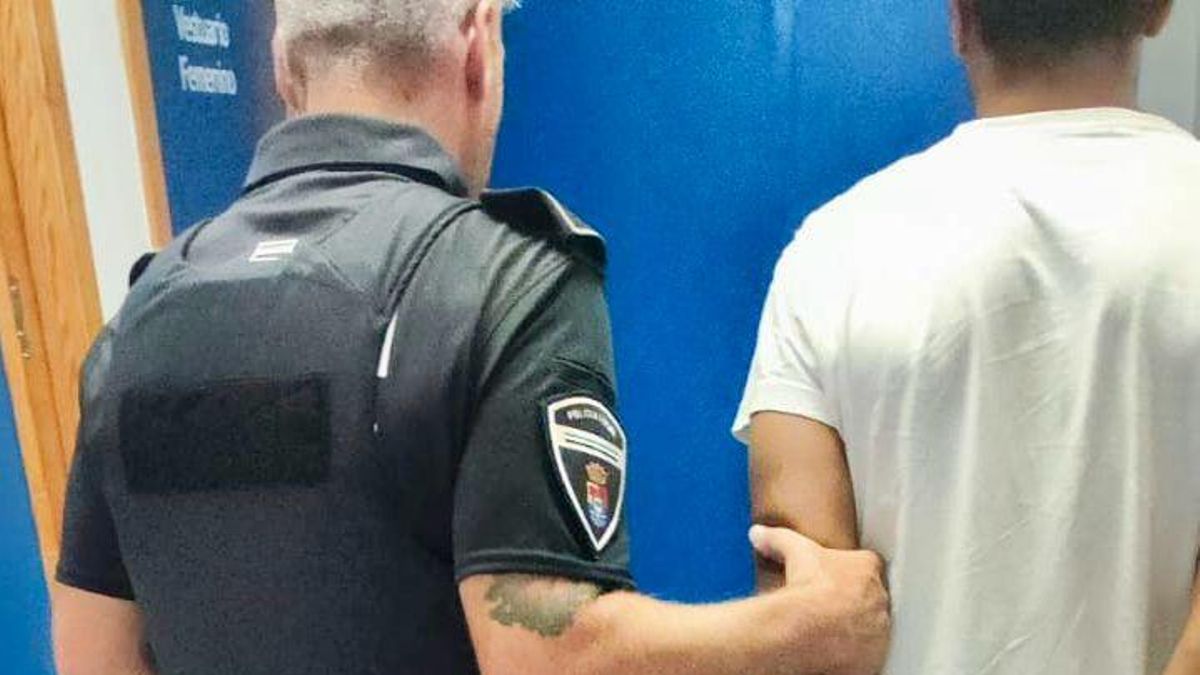 Un agente con el detenido.