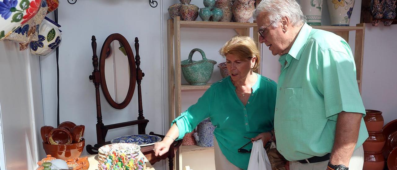 Dos visitantes, en un expositor de la Feria de la Alfarería de La Rambla.