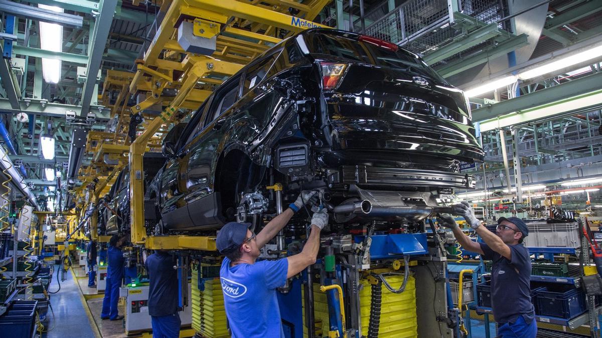 Unos operarios trabajan en la cadena de montaje de vehículos de Ford Almussafes