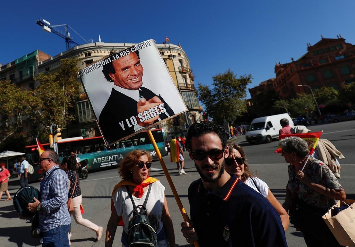 A man carries a sign depicting Spanish singer Julio Iglesias which reads  Puigdemont you messed up and you know it   as demonstrators gathered for a pro-union demonstration organised by the Catalan Civil Society organisation in Barcelona  Spain  October 8  2017  REUTERS Rafael Marchante