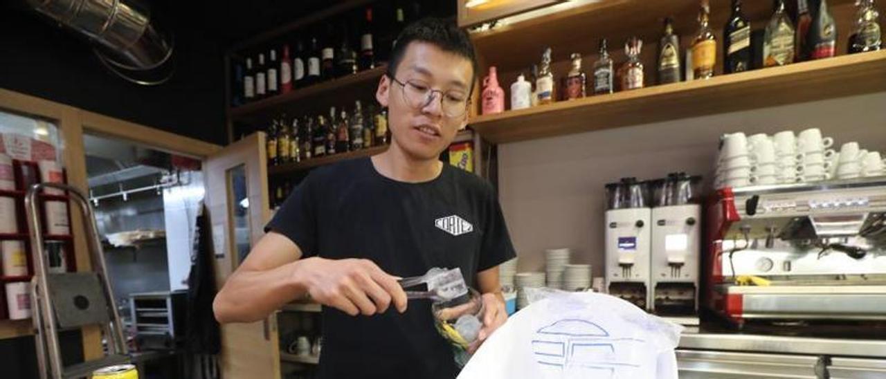 Uno de los trabajadores del bar Cortez en Zaragoza sirve hielo en un vaso. | ÁNGEL DE CASTRO