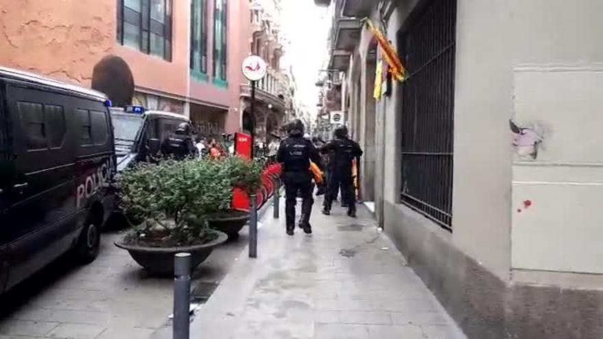 Jóvenes huyen de la policía ante el Palau de la Música.