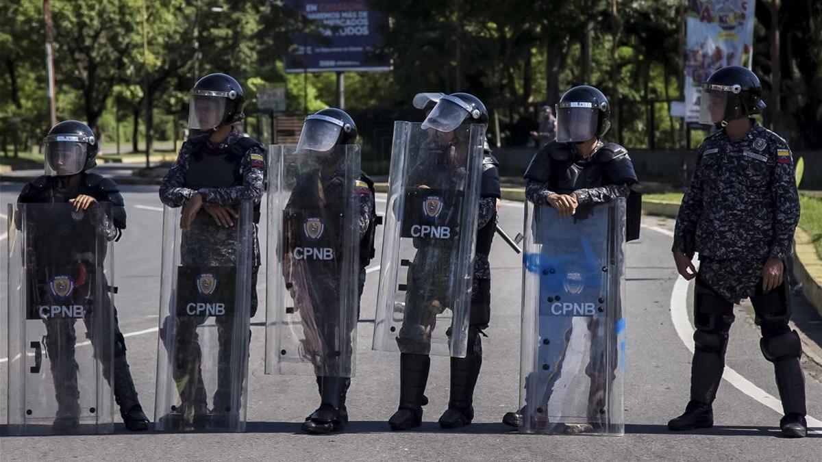 Integrantes del Cuerpo de Policía Nacional Bolivariana (CPNB) vigilan en una calle durante una manifestación de apoyo a un grupo de militares sublevados, el 6 de agosto.