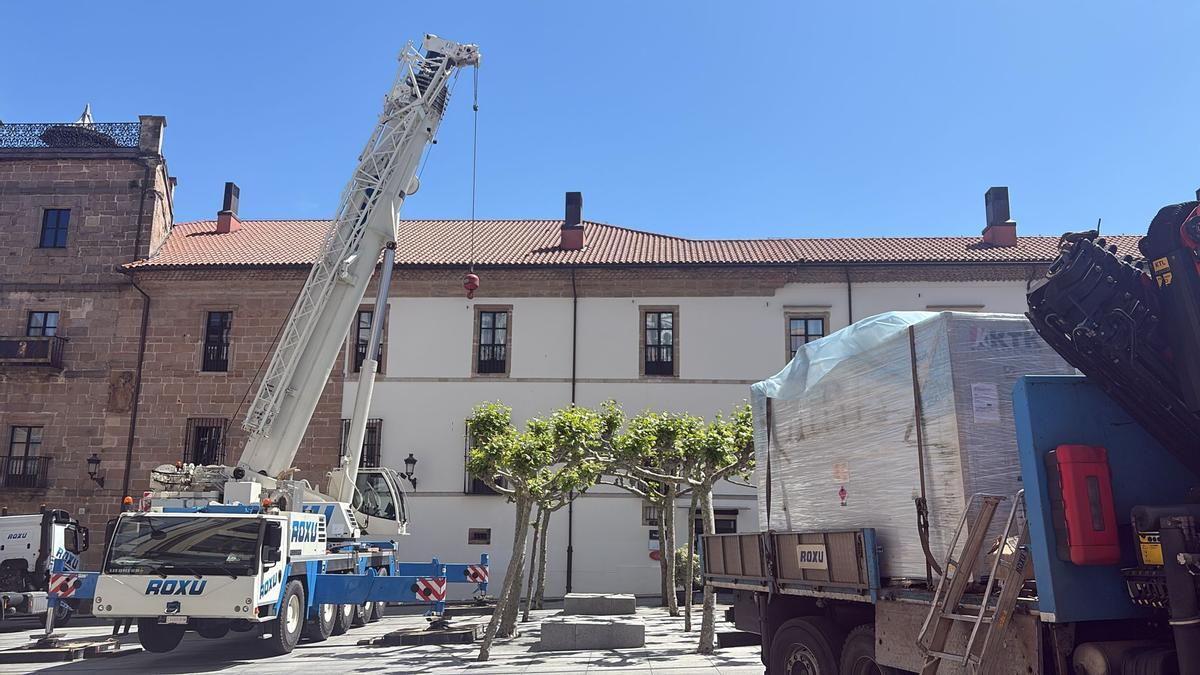 A la izquierda, la grúa de brazo telescópico, a la derecha, el camión con el generador, de fondo, el hotel Palacio de Avilés.