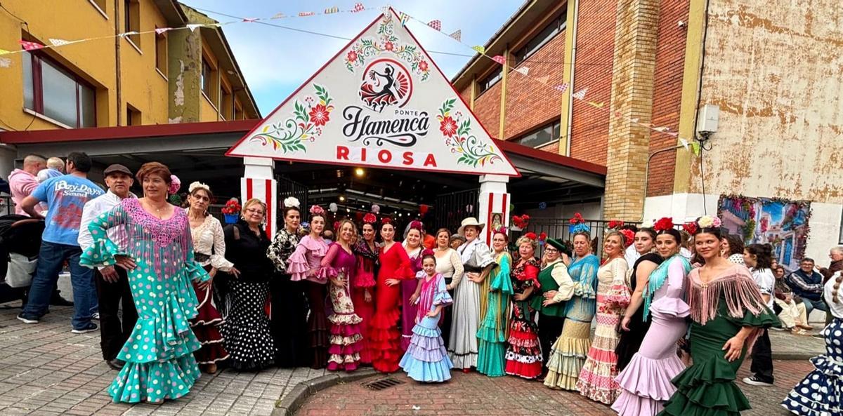 Integrantes del grupo de sevillanas de Riosa posan a la entada del recinto ferial.
