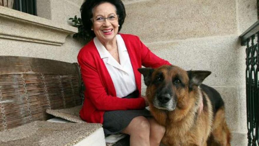 La diseñadora jubidada María Eugenia Ayala, en su casa de la parroquia de Sabarís, en Baiona, con su perro &quot;Dado&quot;.  // Marta G.Brea