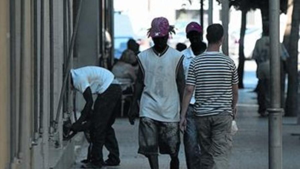 Unos inmigrantes caminan por una céntrica calle de Salt.