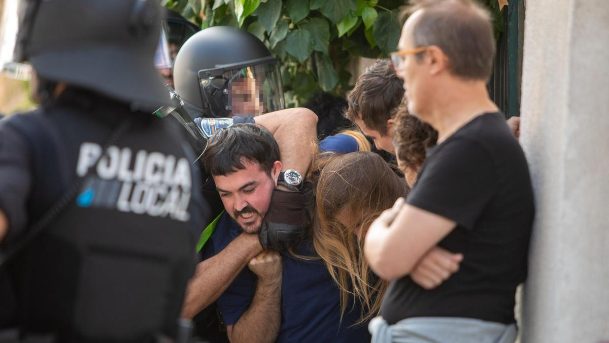 Un agente sujeta a un activista durante el desahucio de  Toñi Cortés y los tres hijos menores  que tiene a su cargo.