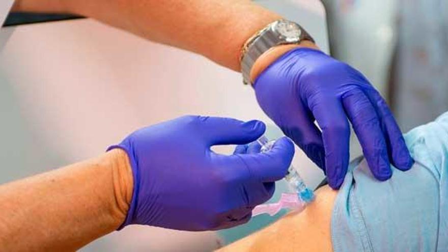 Un sanitario se dispone a administrar una vacuna contra la gripe, en la campaña de 2019.