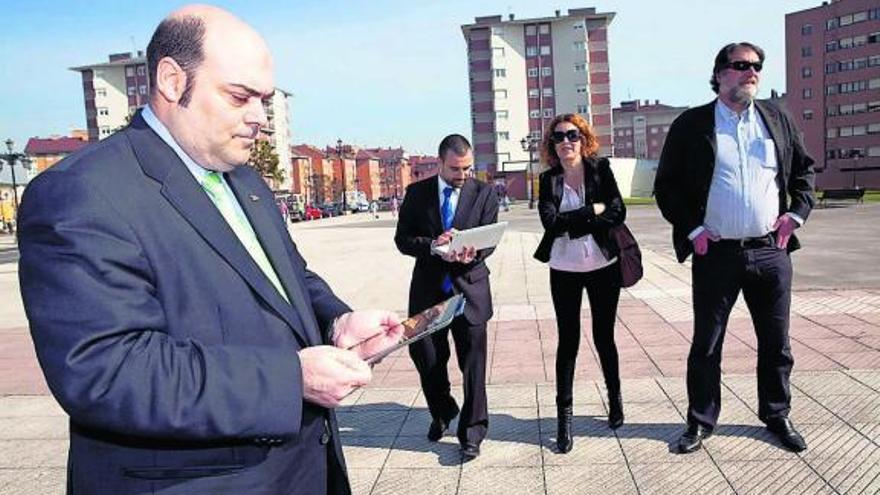 Agustín Iglesias Caunedo usa su tableta digital, con Carlos Giménez, Marta de Diego e Ignacio Huerta al fondo.