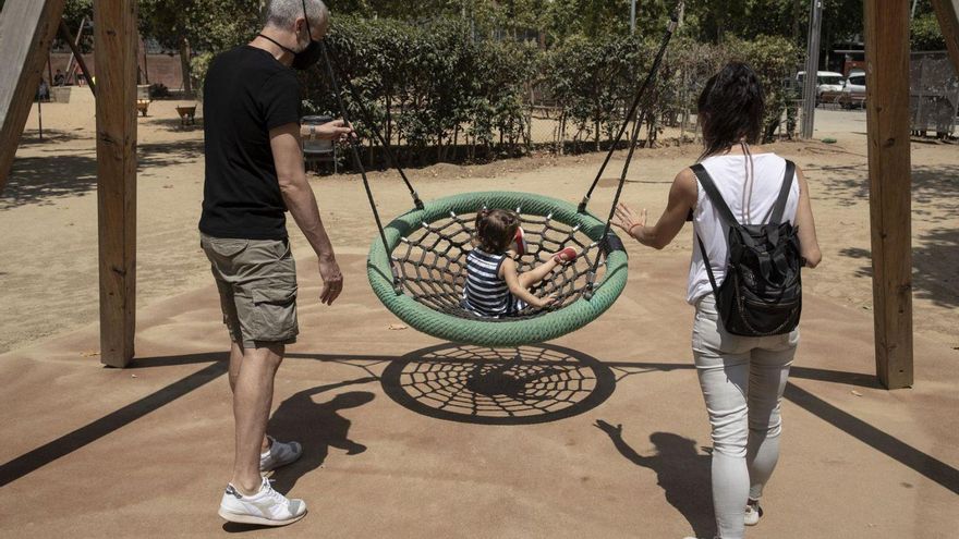 Unos padres, con su hija en el parque.