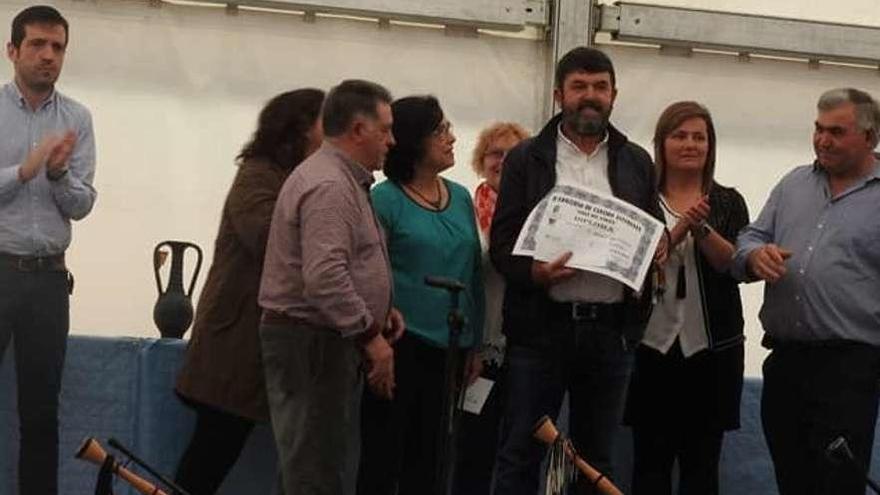 Manuel Castaño, en el centro de la imagen, recogiendo el segundo premio del concurso de tonada cangués el pasado mes de mayo.