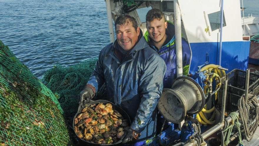 Dos pescadores muestran un capacho lleno de volandeiras, en una imagen de archivo. // Iñaki Abella