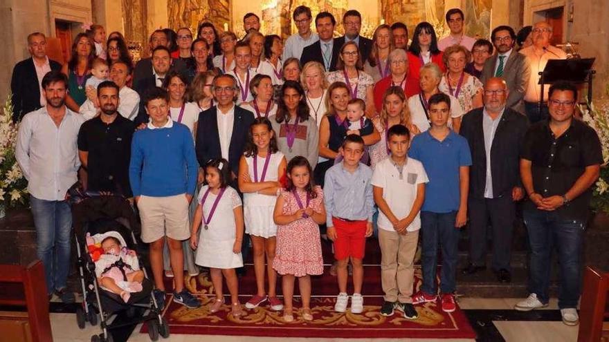 Los nuevos miembros de la cofradía posan con sus medallas junto a la Hermana Mayor, Marora Martín-Caloto, ayer en la Colegiata. // J. Lores