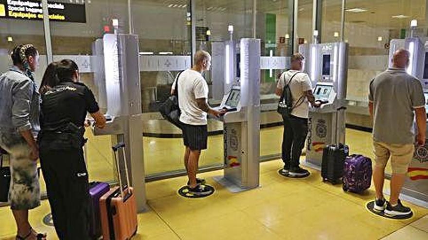 Passatgers passant pel sistema automàtic ABC de l&#039;aeroport, ajudats per un agent del CNP, aquest mes.