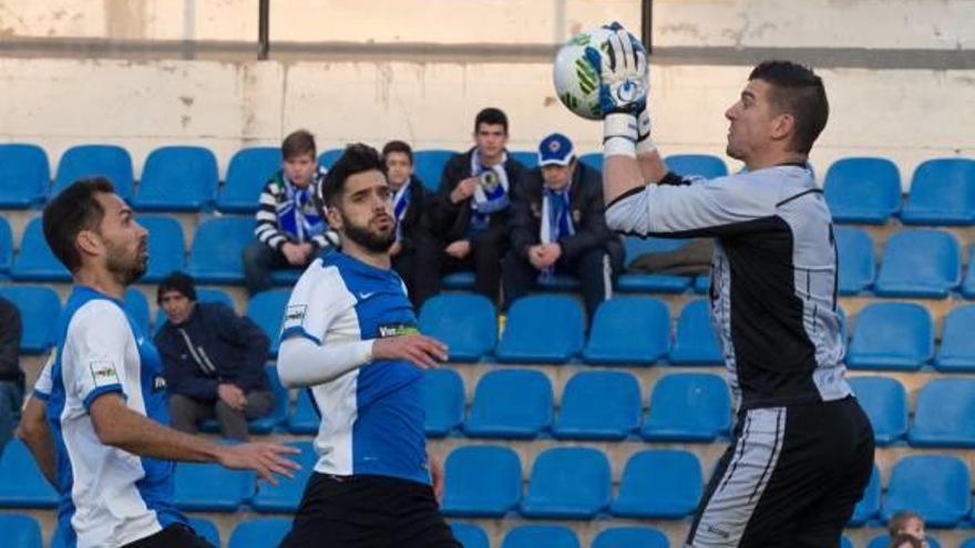 Morales atrapa el balón en el Rico Pérez ante los centrales del Hércules Lolo y Fernando Román en la temporada 16/17.