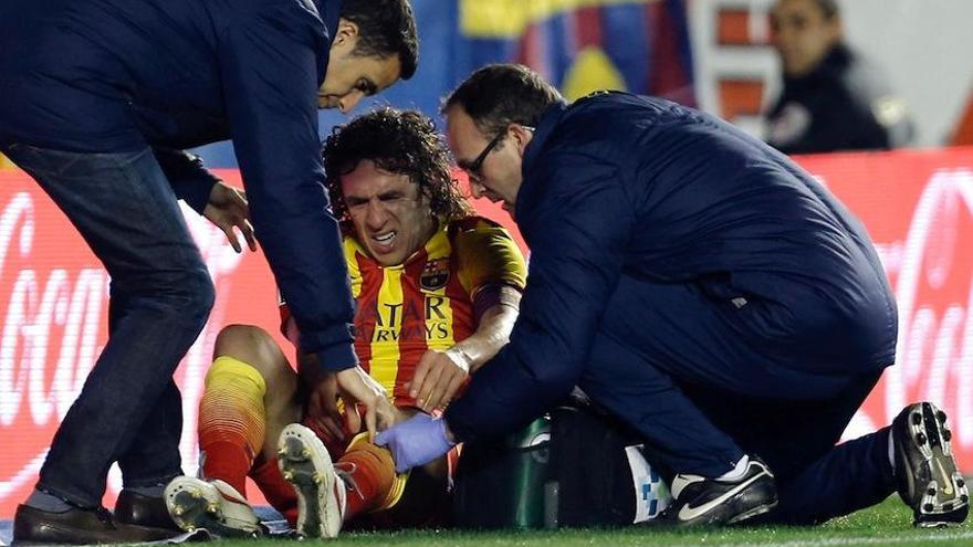 Puyol, atendido por miembros del cuerpo médico, en el partido de ayer.