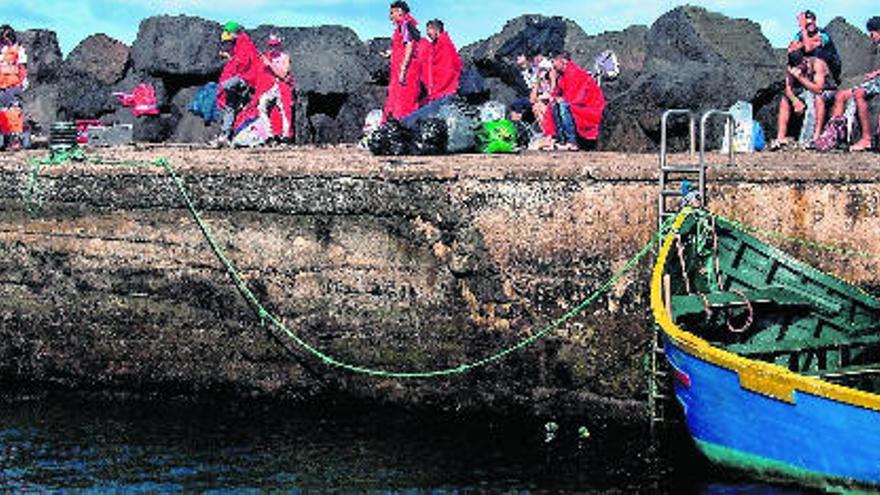 Los efectivos de Cruz Roja atienden a la treintena de inmigrantes que llegaron  ayer a las costas de La Santa a bordo de una patera