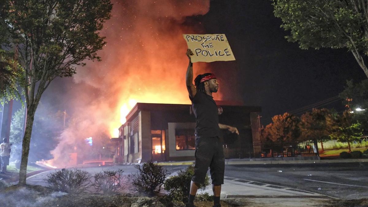 Uno de los manifestantes frente al restaurante Wendy's de Atlanta, en llamas, anoche.