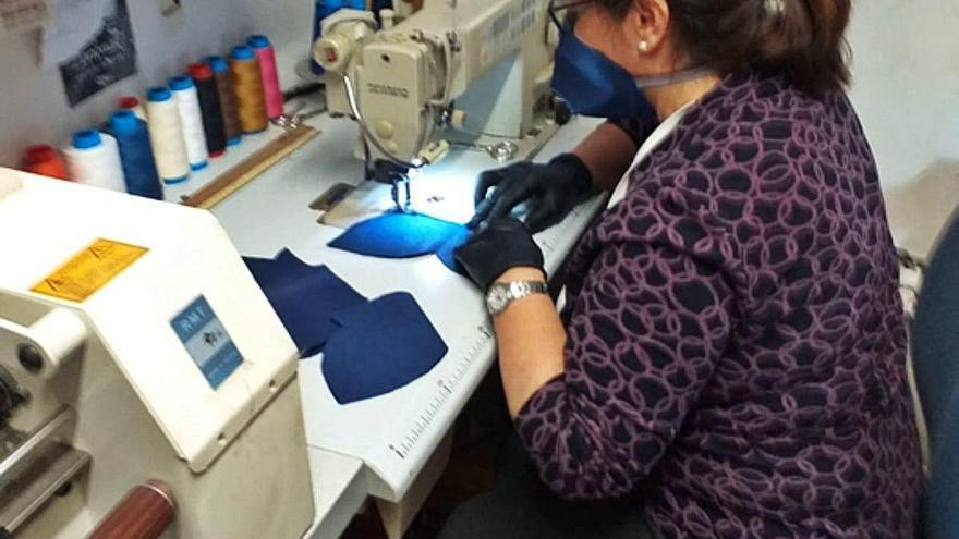 Yolanda Villar realizando mascarillas con material TNT.