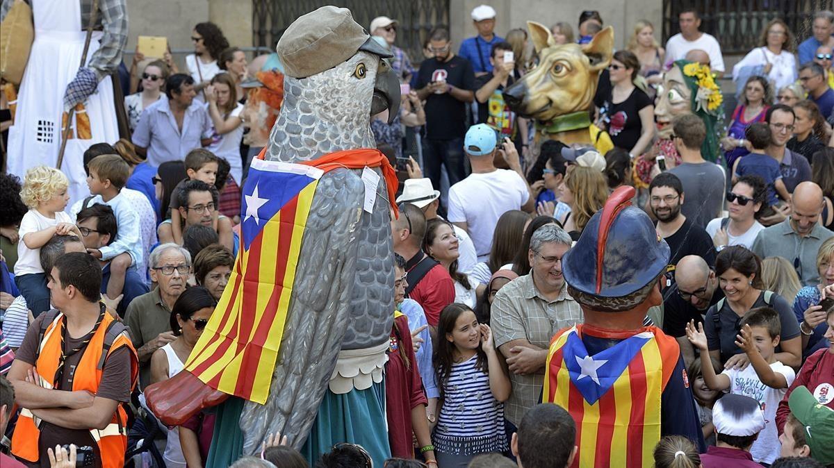 Un gigante ondea una estelada en la plaça Sant Jaume durante el encuentro de gigantes y cabezudos.