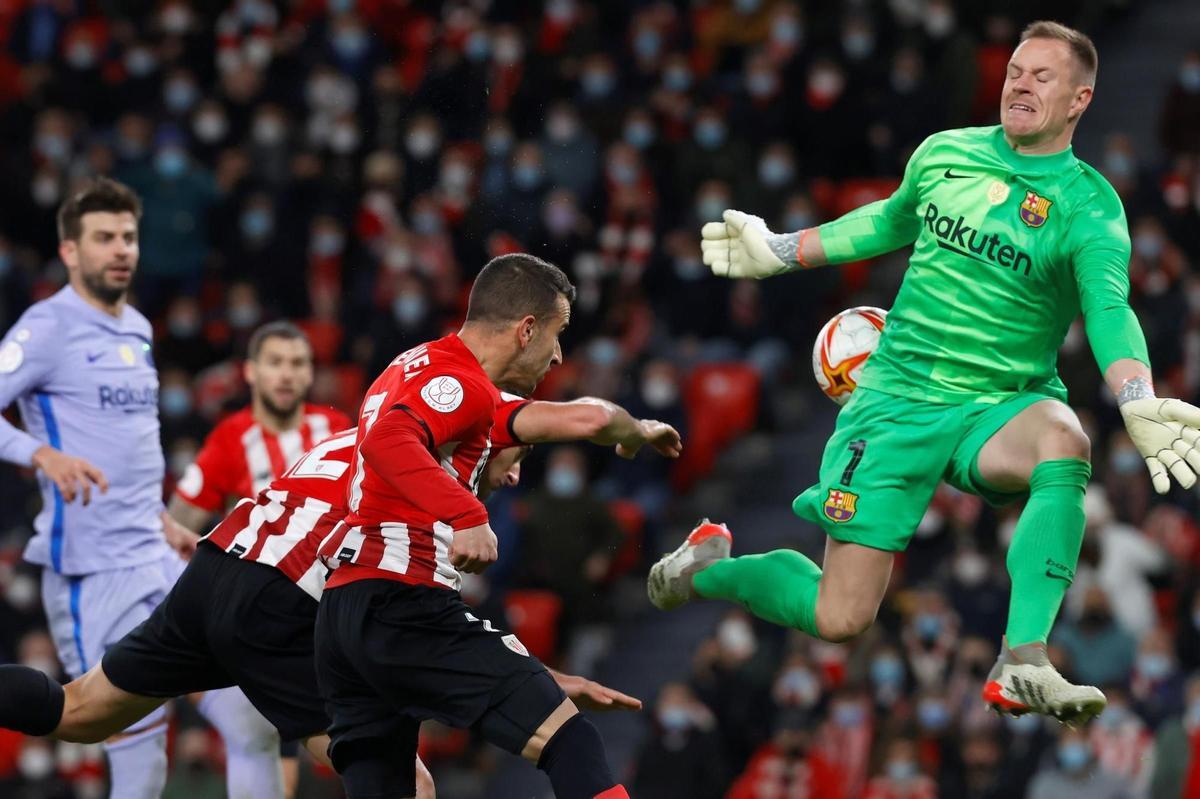 BILBAO, 20/01/2022.- El guardameta alemán del FC Barcelona, Marc-André ter Stegen (d), intenta detener el remate del delantero del Athletic Club, Álex Belenguer (2d), en la jugada que ha significado el segundo gol del equipo bilbaino durante el encuentro correspondiente a los octavos de final de la Copa del Rey que disputan hoy jueves en el estadio de San Mamés, en Bilbao. EFE / Miguel Toña.