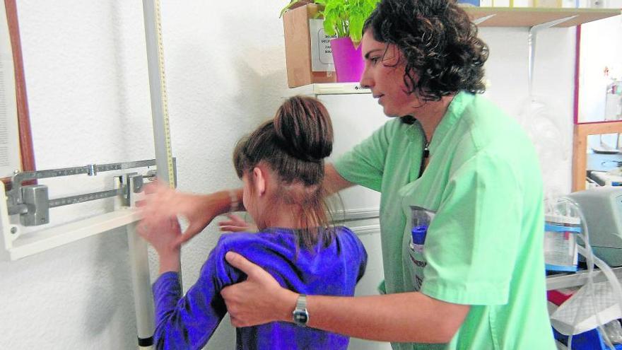 Enfermera en un Colegio de Educación Especial atendiendo a una alumna.