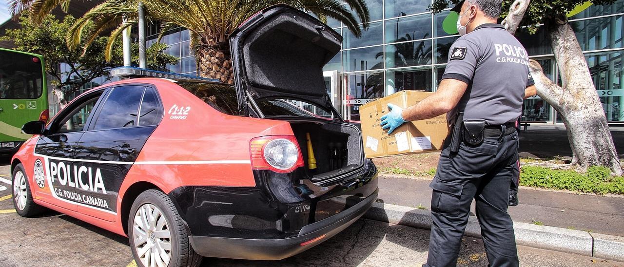 Un agente de la Policía Canaria reparte mascarillas durante el confinamiento.