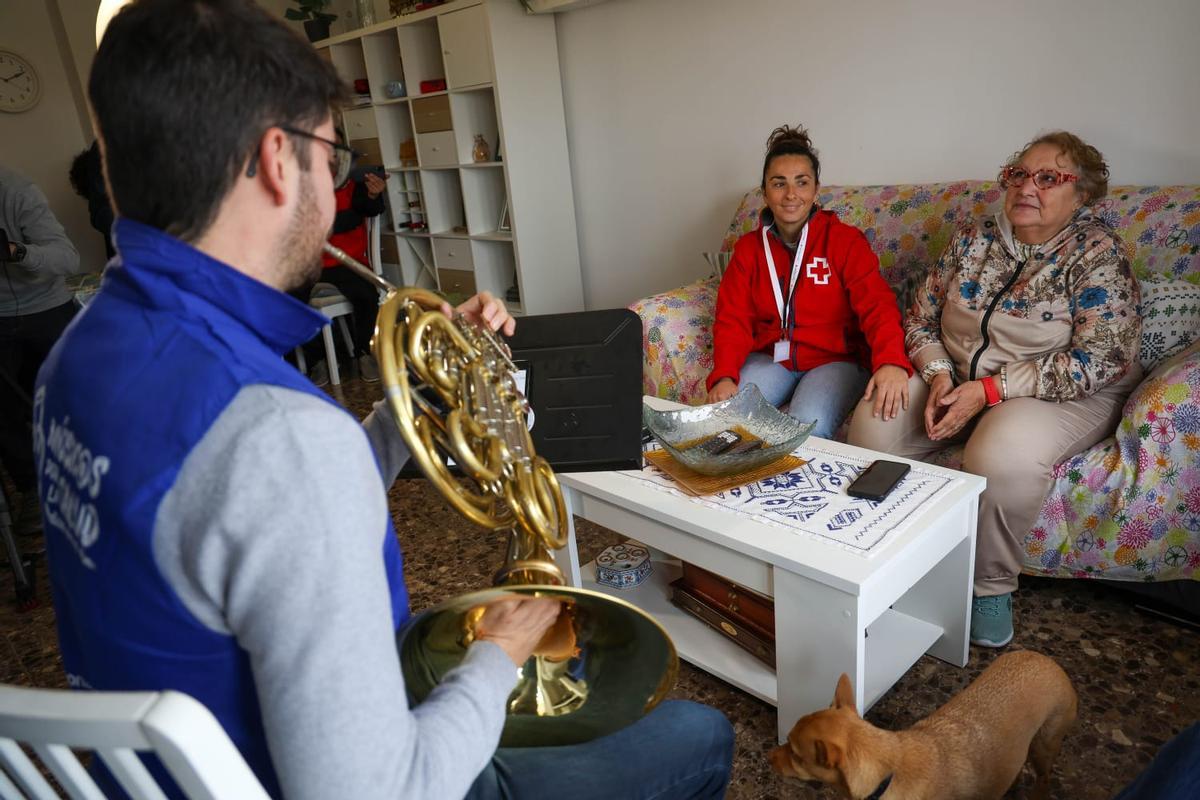 Pilar junto a Elisa, de Cruz Roja, en el sofá de su comedor escuchan a Eliseo