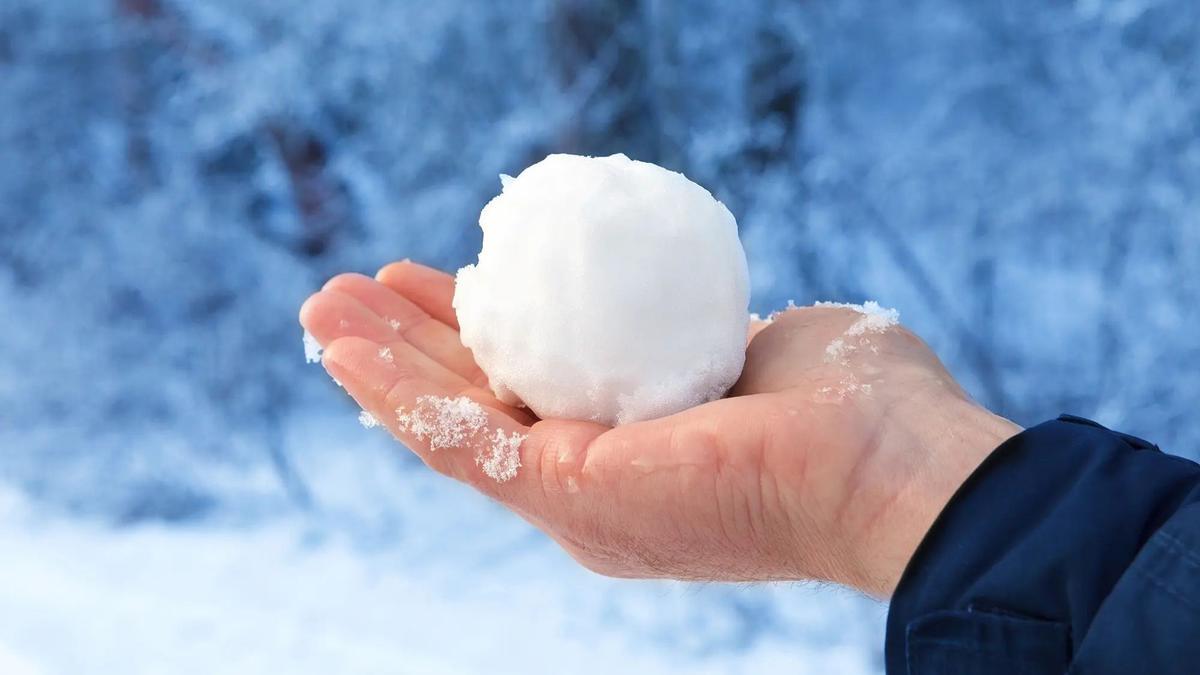 Un hombre sujeta una bola de nieve.