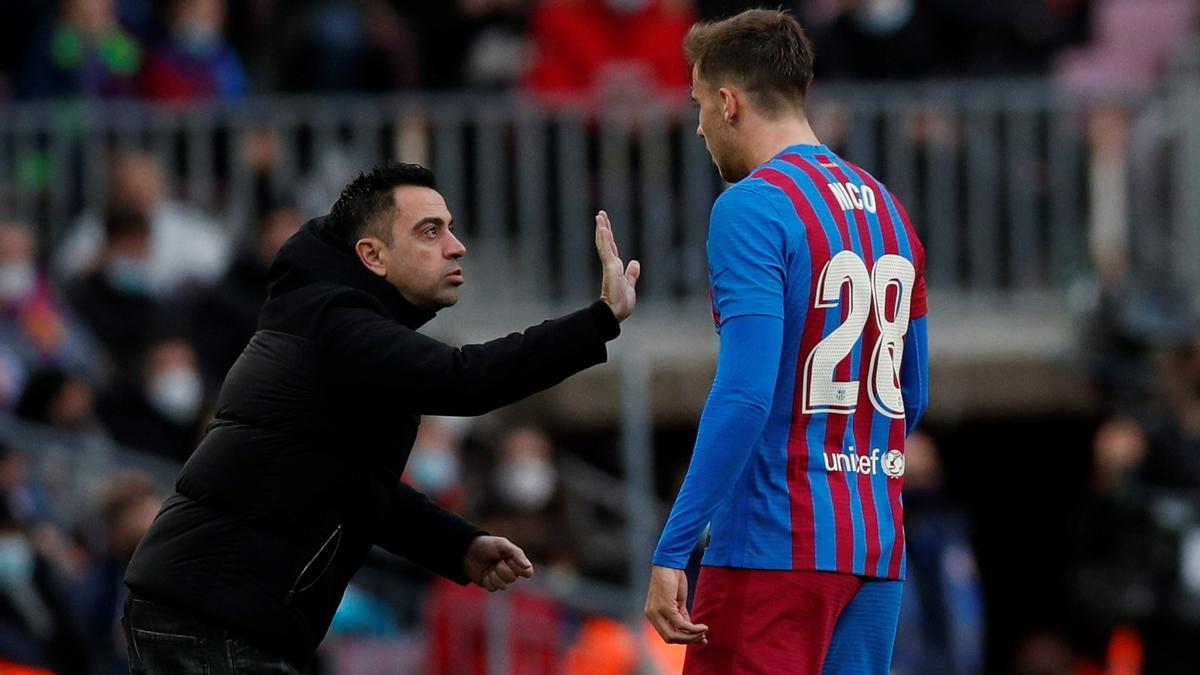 Nico González recibe las instrucciones de Xavi durante un partido