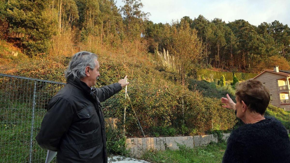 Unos vecinos de Río Frío, en Chapela, muestran la masa forestal pegada a las casas.