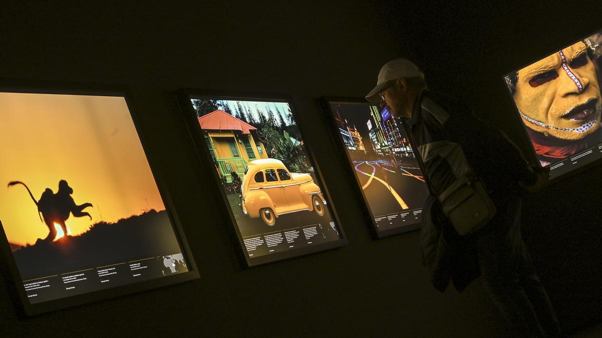 Un visitante observa las fotografías con tonalidad amarilla