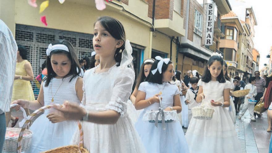 Niñas lanzan pétalos en la calle Herreros, ayer por la tarde durante la procesión del Corpus Christi.