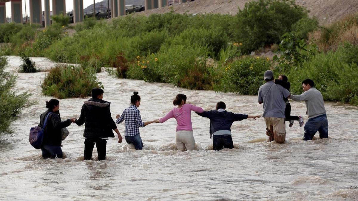 Migrantes de Centroamérica forman una cadena humana para cruzar el Río Bravo y entrar en Estados Unidos.