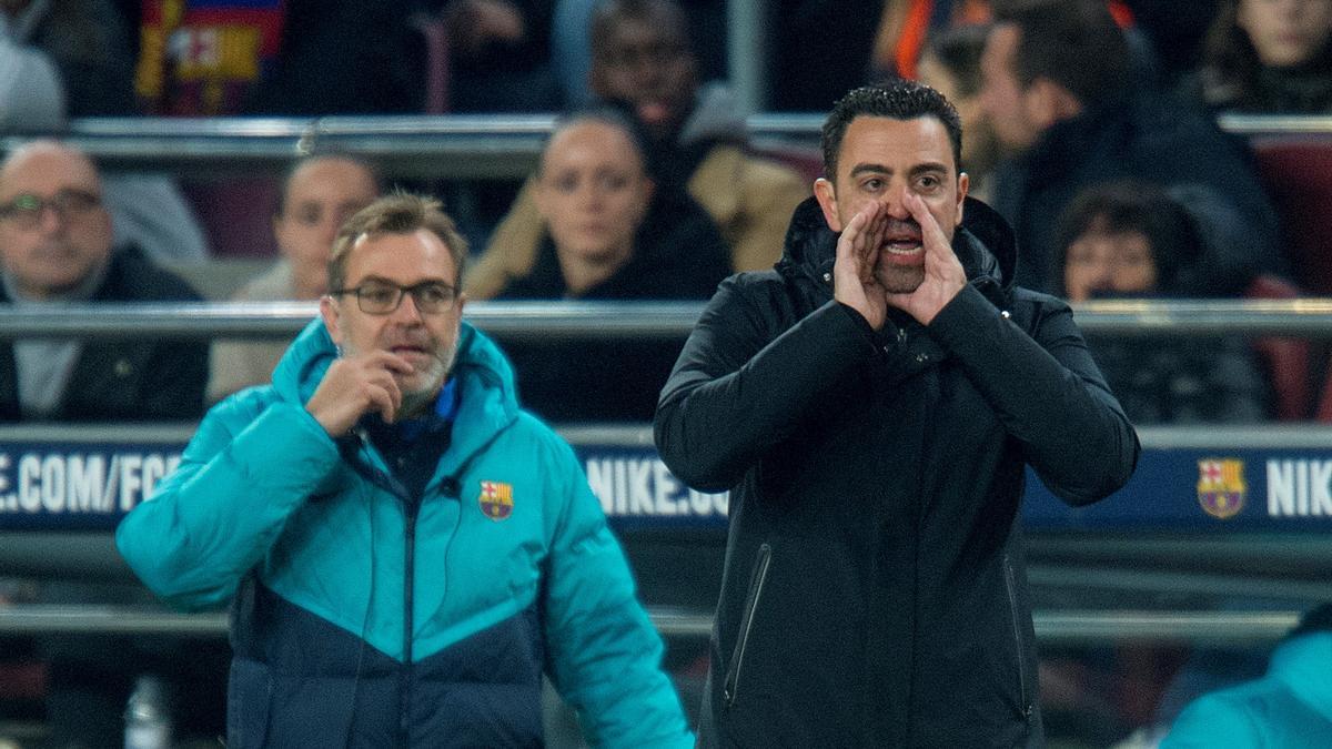 Xavi animando desde la banda durante el Barça-Cádiz ante la mirada de Òscar Hernández, su segundo entrenador y hermano.