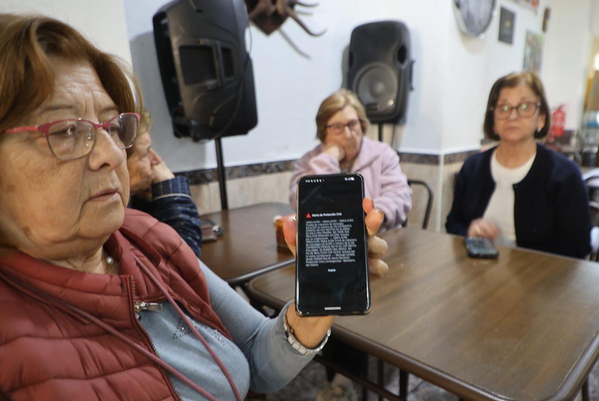 Una mujer muestra el mensaje recibido en su móvil.