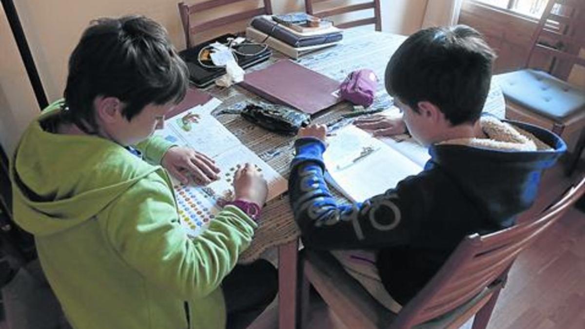 Deberes 8 Dos niños de quinto de primaria hacen sus tareas escolares.