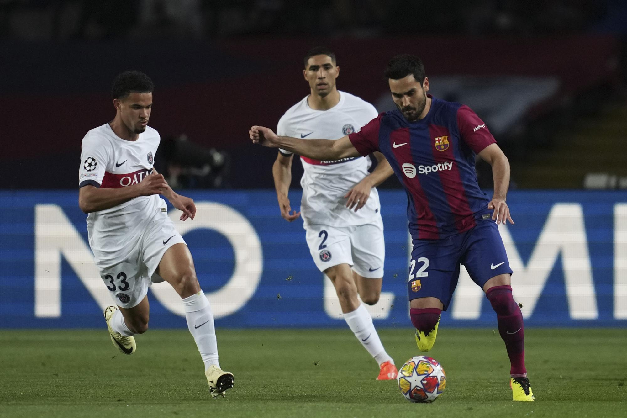 Barcelona's Ilkay Gundogan, right, runs with the ball past PSG's Warren Zaire-Emery, left, during the Champions League quarterfinal second leg soccer match between Barcelona and Paris Saint-Germain at the Olimpic Lluis Companys stadium in Barcelona, Spain, Tuesday, April 16, 2024. (AP Photo/Emilio Morenatti)