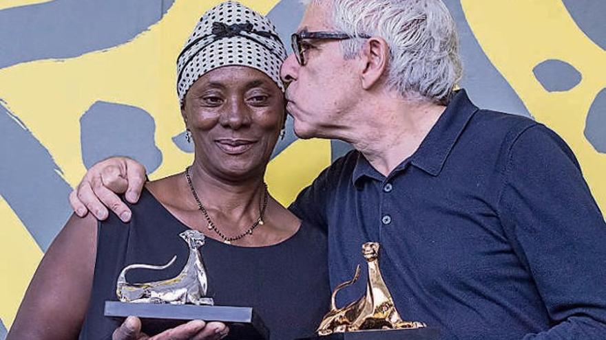 Pedro Costa y la actriz Vitalina Varela, con sus premios.  // Efe