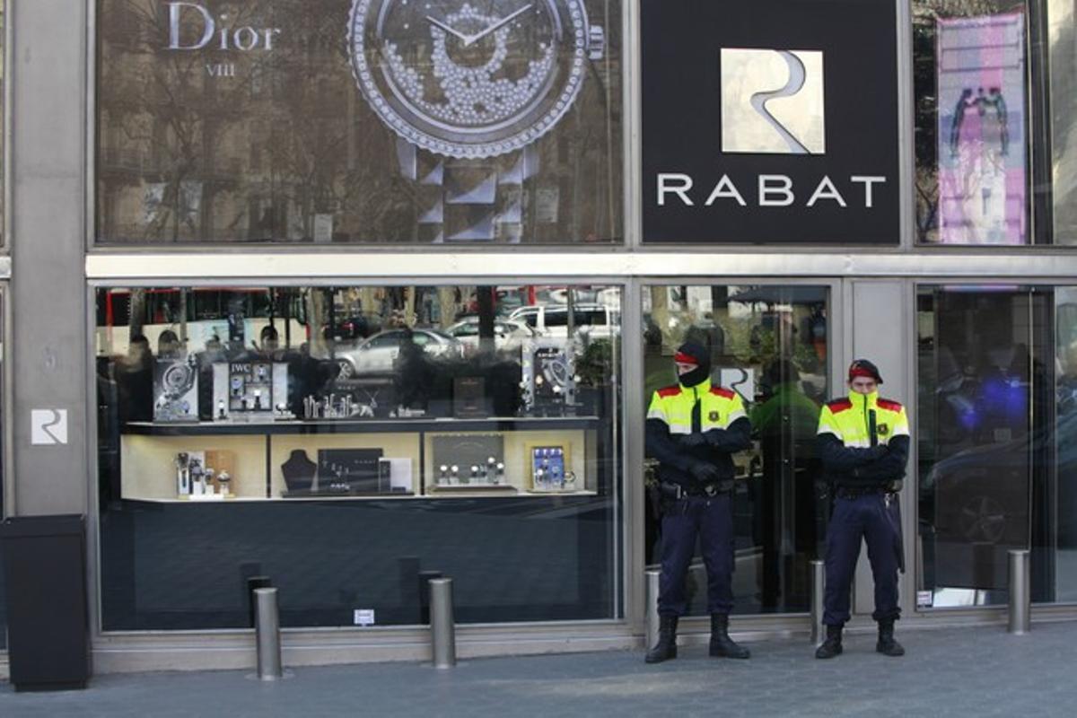 Dos mossos vigilen l’entrada de la joieria Rabat durant el registre policial de l’establiment. Dos mossos vigilen l’entrada de la joieria Rabat durant el registre policial de l’establiment.