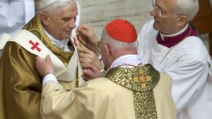 Benedicto XVI se coloca la insignia papal con la ayuda del obispo Piero Marini, en la plaza de San Pedro, el 24 de abril del 2005.
