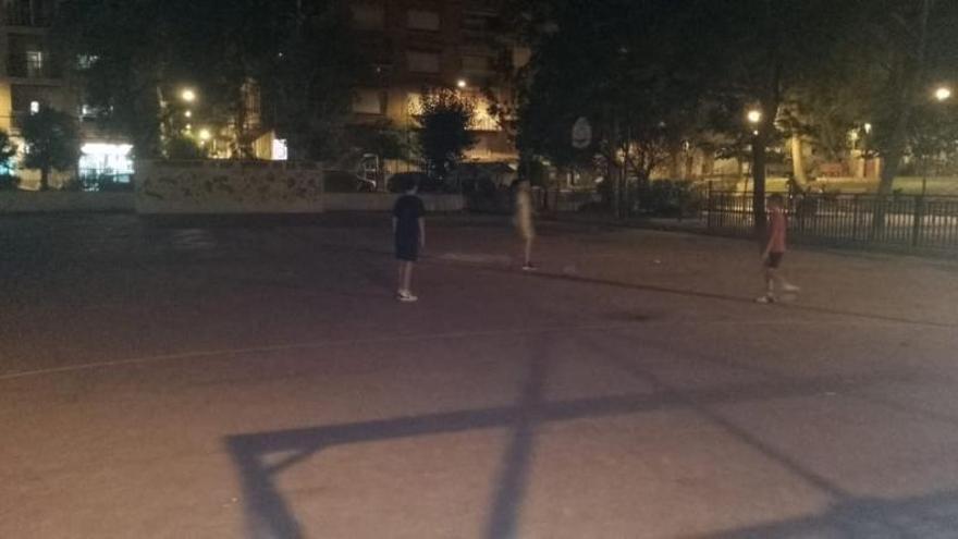 Tres niños juegan a la pelota, a oscuras, en la pista de La Viña. | L.O.