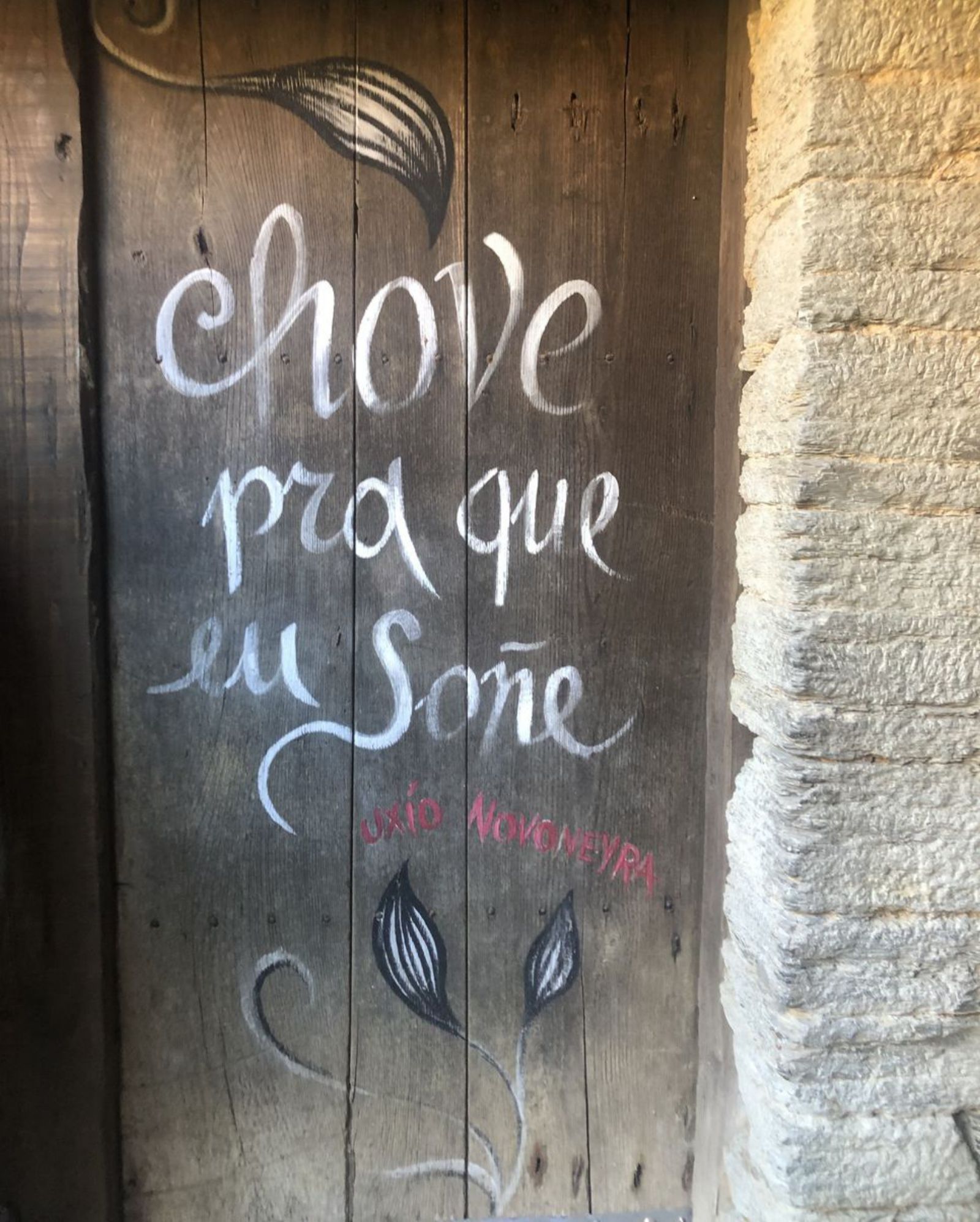 “Llueve para que yo sueñe” escrito en una ventana