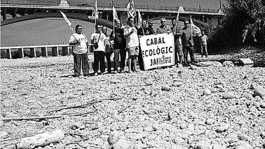 Manifestantes de Castellón y Manuel, ayer en el Albaida antes de la llegada del agua.