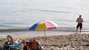 Archivo - Varias personas disfrutan tomando el sol en la playa de la Malagueta.